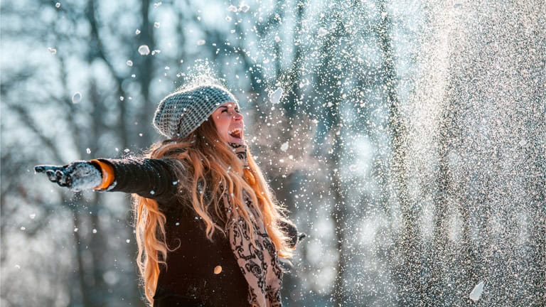 glückliche Frau im Winter Immunabwehr schnee werfen